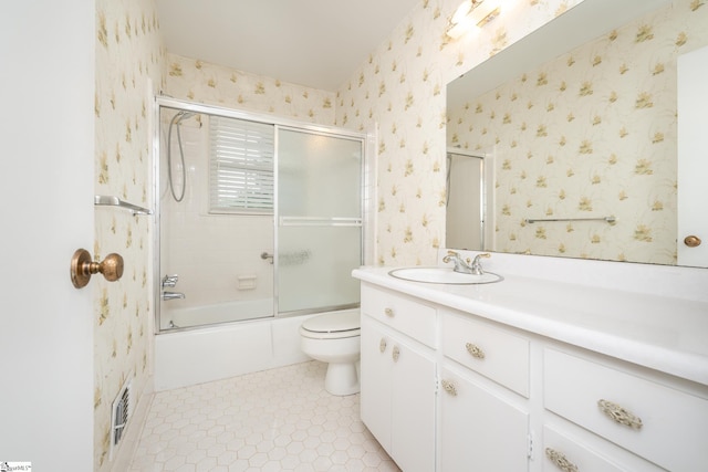 full bathroom featuring vanity, shower / bath combination with glass door, toilet, and tile patterned flooring