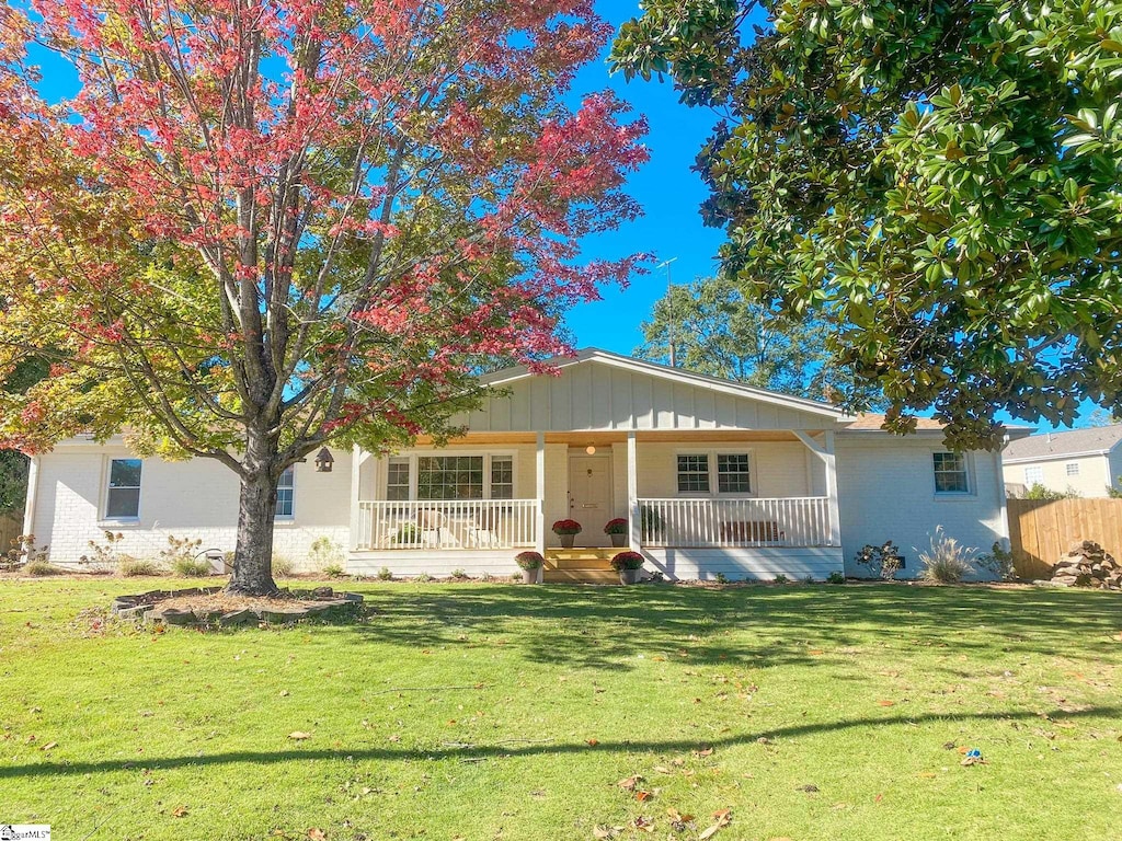 ranch-style house with covered porch and a front yard