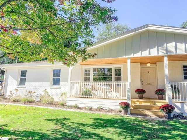 view of front of property featuring covered porch and a front lawn