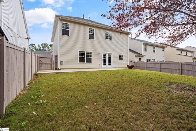 back of house with a patio area and a yard