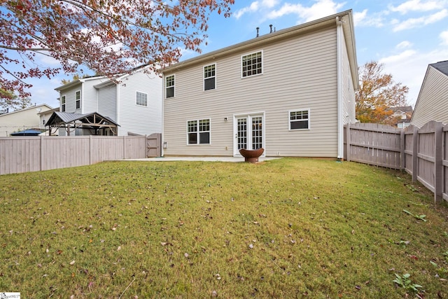 rear view of house with a patio and a yard