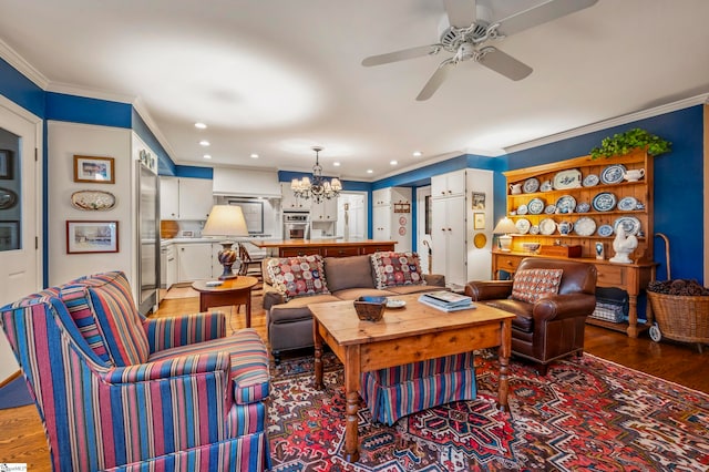 living room featuring ornamental molding, hardwood / wood-style flooring, and ceiling fan with notable chandelier