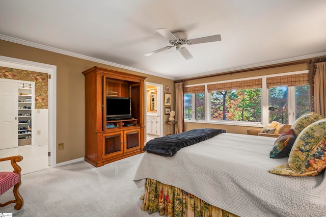 carpeted bedroom with connected bathroom, ornamental molding, and ceiling fan