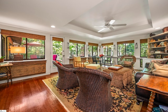 living room featuring ceiling fan, a raised ceiling, and dark hardwood / wood-style floors