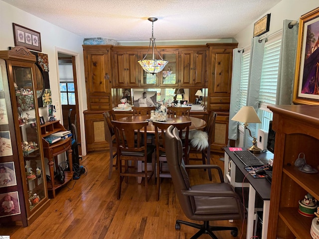 dining area featuring a textured ceiling and wood-type flooring