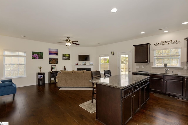 kitchen with a wealth of natural light, a breakfast bar, and dark hardwood / wood-style flooring