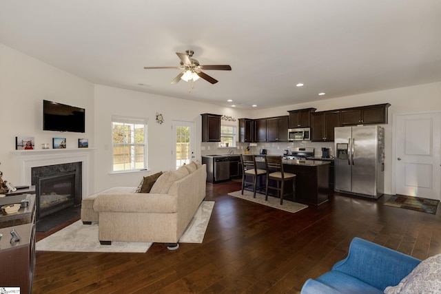 living room with dark hardwood / wood-style floors, a fireplace, and ceiling fan