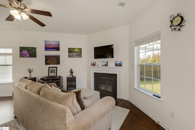 living room featuring ceiling fan and dark hardwood / wood-style flooring