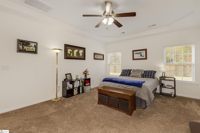 bedroom with carpet floors, a raised ceiling, and ceiling fan