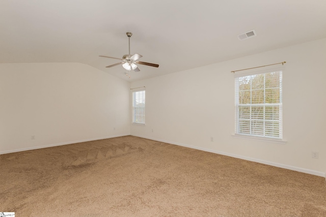 empty room with a healthy amount of sunlight, carpet flooring, and lofted ceiling