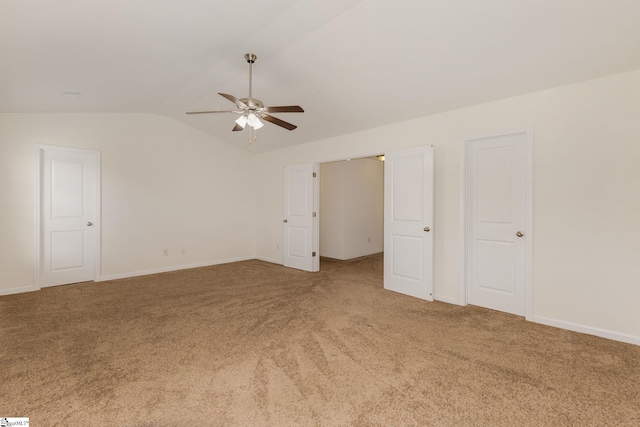 empty room with vaulted ceiling, carpet flooring, and ceiling fan