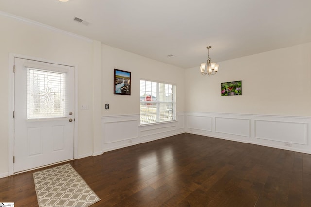 entryway with an inviting chandelier, plenty of natural light, and dark hardwood / wood-style flooring