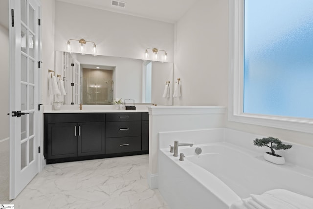 bathroom featuring french doors, vanity, and independent shower and bath