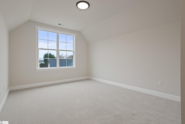 additional living space with carpet floors and vaulted ceiling