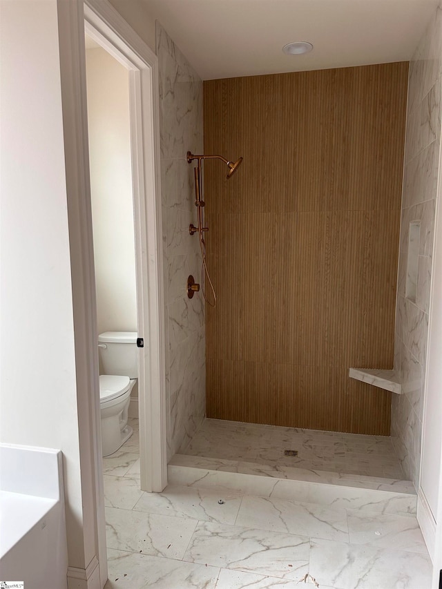 bathroom featuring a tile shower and toilet