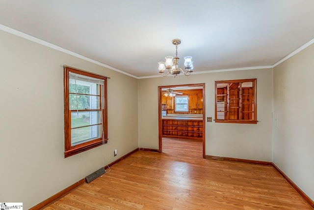 unfurnished dining area featuring light hardwood / wood-style floors, ornamental molding, and ceiling fan with notable chandelier