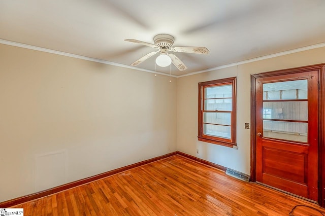 empty room with ornamental molding, hardwood / wood-style flooring, and ceiling fan