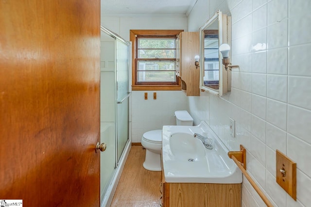 bathroom featuring toilet, an enclosed shower, vanity, and wood-type flooring