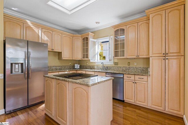 kitchen with light brown cabinetry, a kitchen island, stainless steel appliances, and dark hardwood / wood-style floors