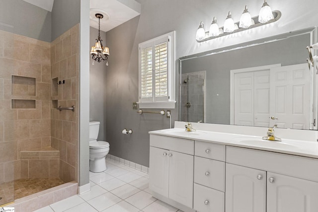 bathroom with vanity, tiled shower, toilet, and tile patterned flooring