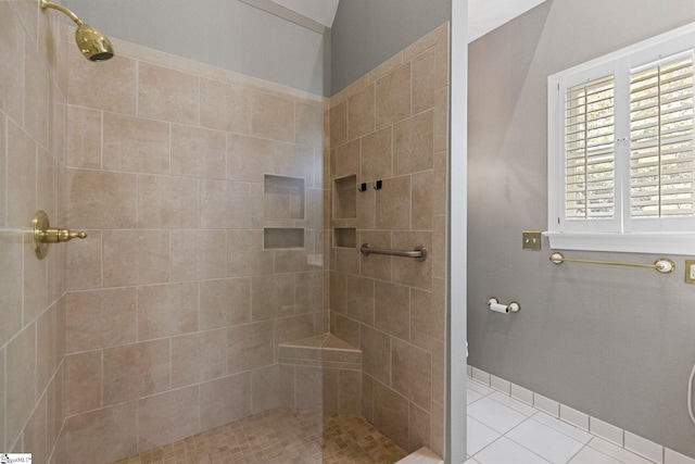 bathroom with tiled shower and tile patterned floors