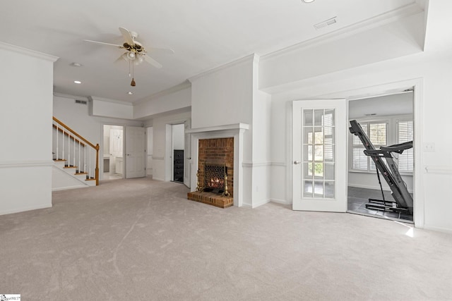 unfurnished living room with ornamental molding, light colored carpet, and a fireplace