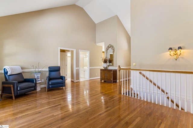 living area featuring hardwood / wood-style flooring and high vaulted ceiling