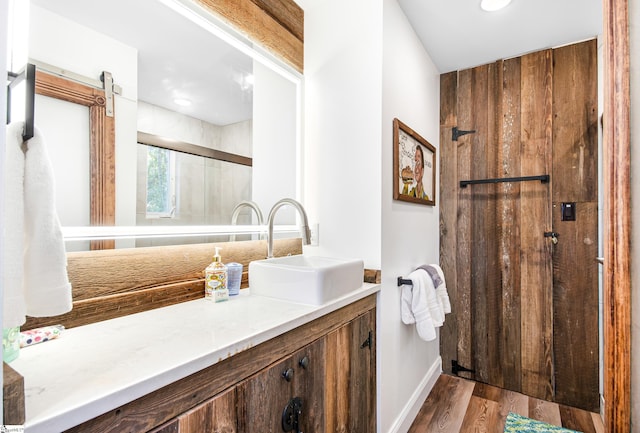 bathroom with vanity, walk in shower, and hardwood / wood-style floors