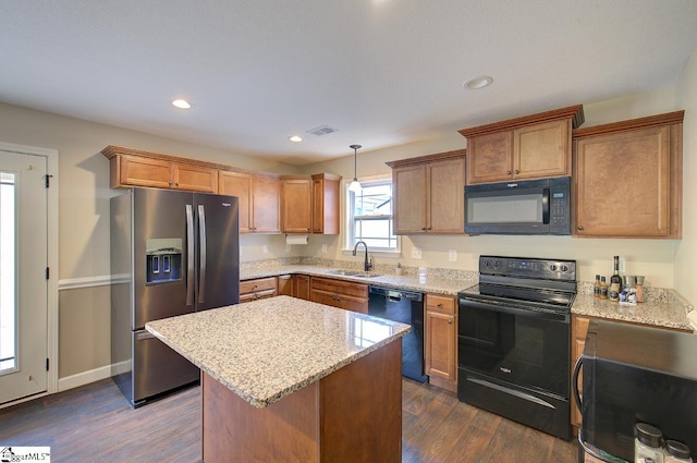 kitchen with hanging light fixtures, dark hardwood / wood-style flooring, black appliances, sink, and a center island