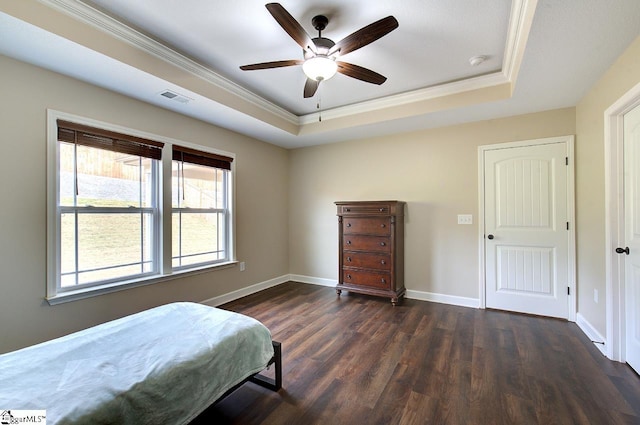 bedroom with ceiling fan, crown molding, a tray ceiling, and dark hardwood / wood-style floors