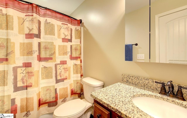 bathroom with toilet, curtained shower, and vanity