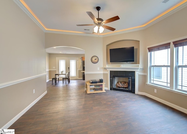 unfurnished living room featuring ornamental molding, a fireplace, dark hardwood / wood-style floors, and ceiling fan