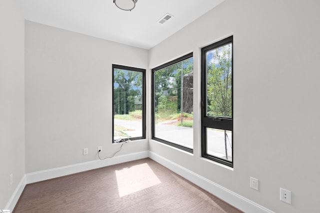 unfurnished room with hardwood / wood-style flooring