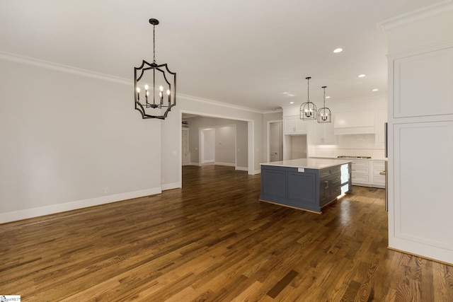 kitchen featuring ornamental molding, white cabinets, dark wood finished floors, and a notable chandelier