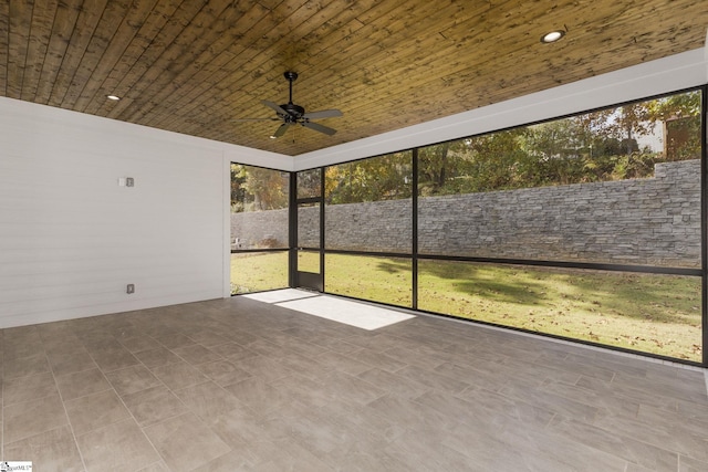 unfurnished sunroom featuring wooden ceiling and a ceiling fan