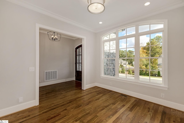 unfurnished room featuring baseboards, dark wood finished floors, visible vents, and crown molding