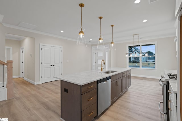 kitchen with appliances with stainless steel finishes, dark brown cabinetry, light hardwood / wood-style floors, and sink