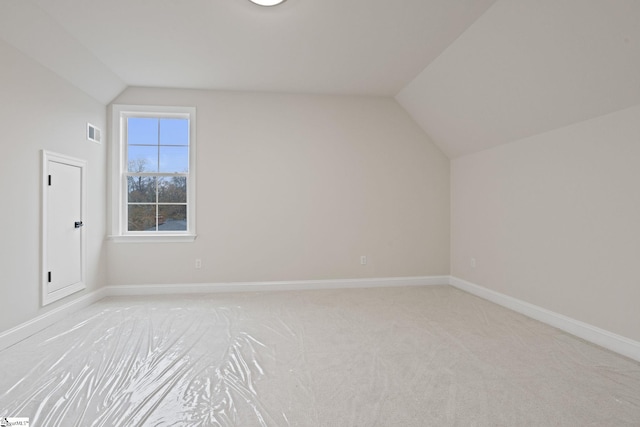 bonus room featuring light colored carpet and vaulted ceiling