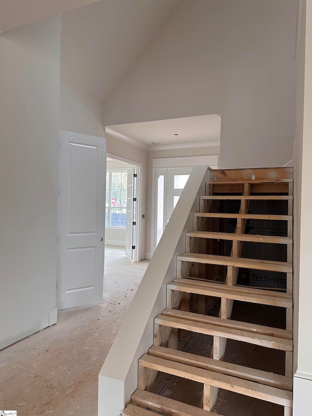 staircase featuring high vaulted ceiling