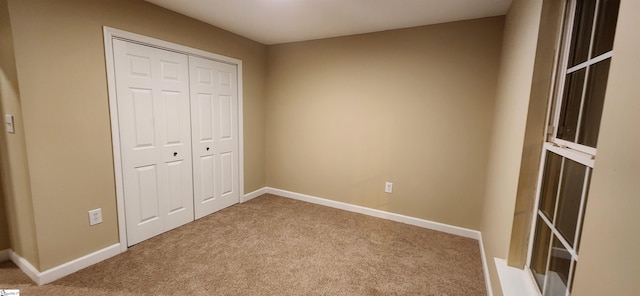 unfurnished bedroom featuring light carpet and a closet