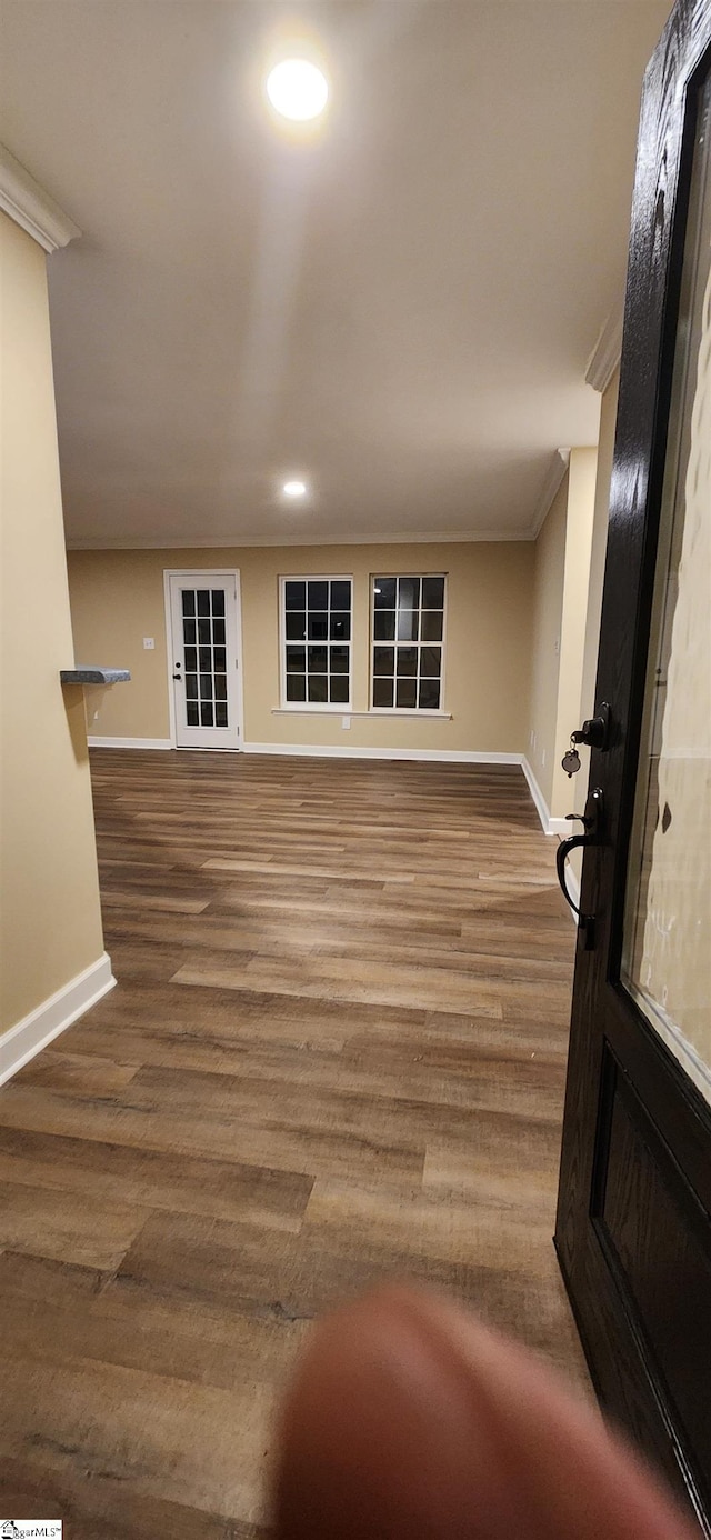 interior space with hardwood / wood-style floors and crown molding