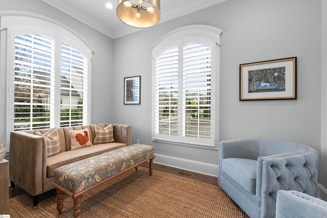 sitting room featuring hardwood / wood-style floors, a wealth of natural light, and ornamental molding