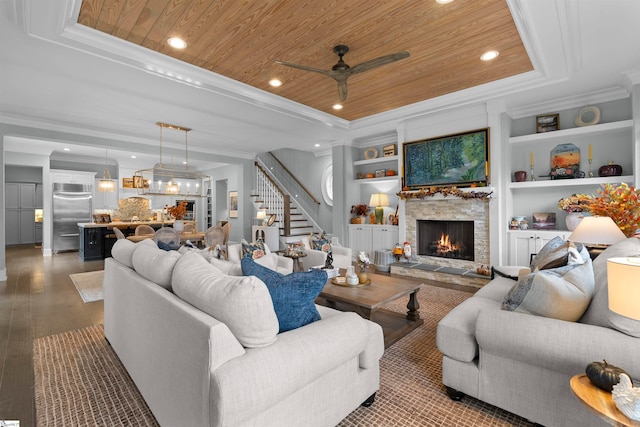 living room with built in shelves, a fireplace, hardwood / wood-style flooring, a tray ceiling, and wooden ceiling