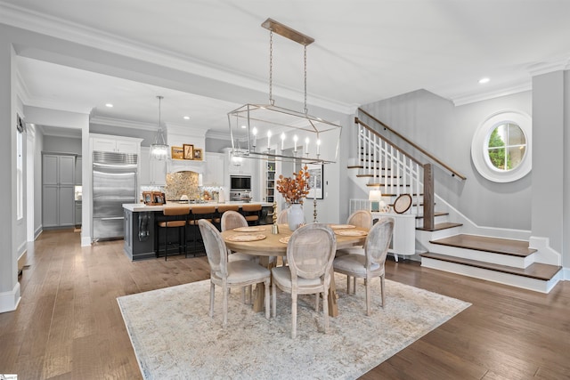 dining area featuring dark hardwood / wood-style flooring, a chandelier, and crown molding