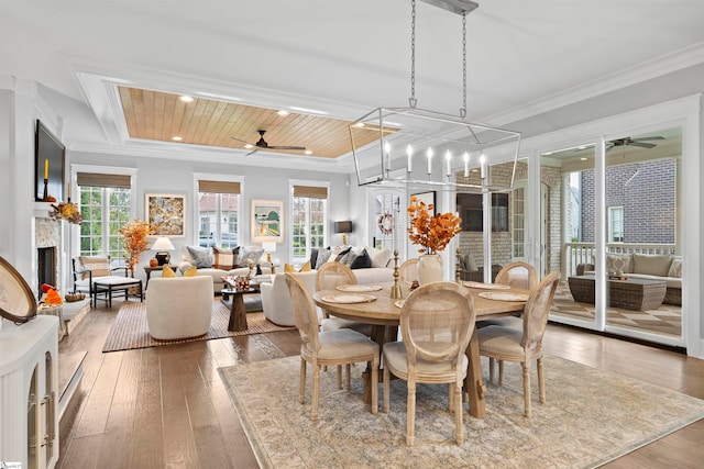 dining room with hardwood / wood-style floors, ceiling fan with notable chandelier, crown molding, and wooden ceiling