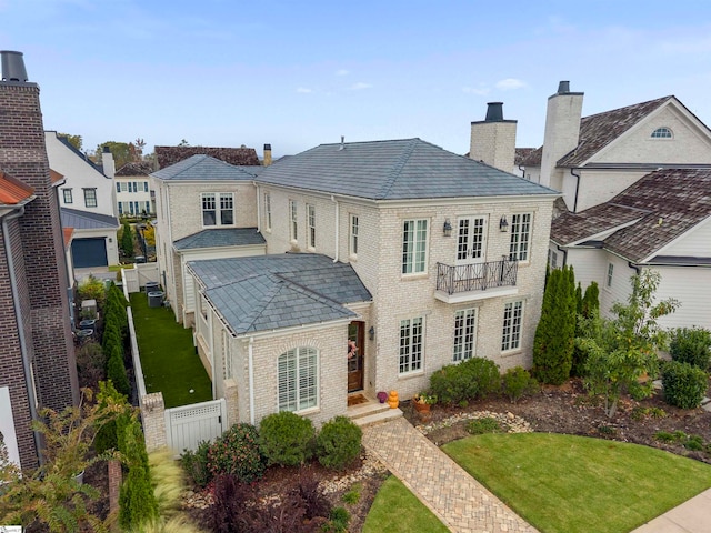 view of front of house with a garage, a front lawn, and a balcony