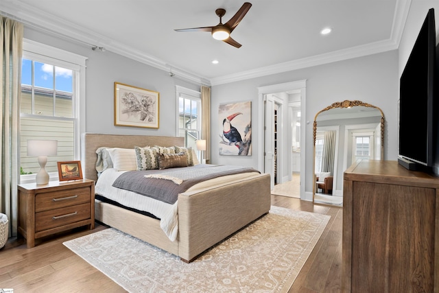 bedroom featuring ceiling fan, light hardwood / wood-style flooring, and ornamental molding