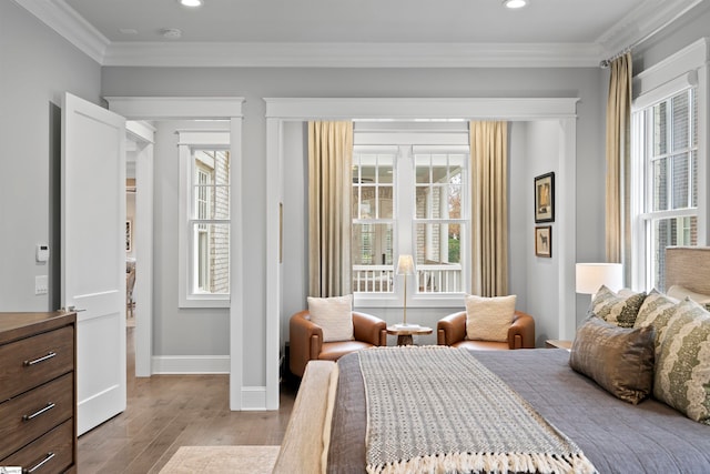 bedroom featuring ornamental molding, multiple windows, and light hardwood / wood-style floors