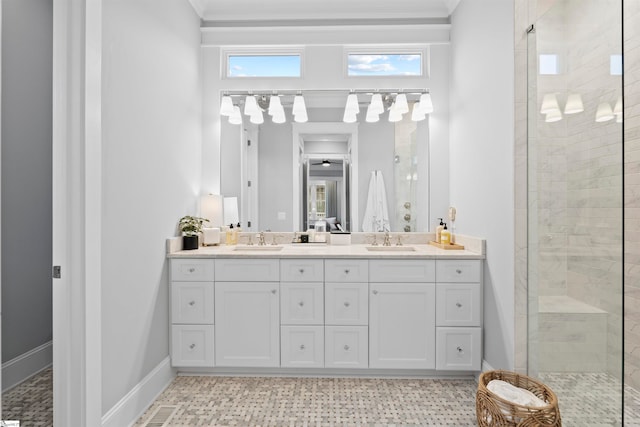 bathroom with a shower with shower door, vanity, and ornamental molding