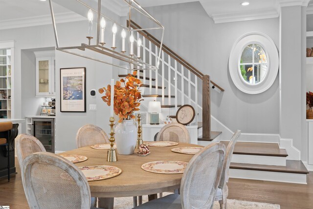 dining space with hardwood / wood-style floors, wine cooler, indoor bar, and ornamental molding